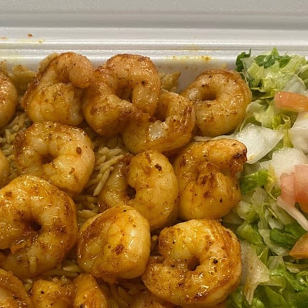 Philly Halal Kitchen's shrimp over rice with a side salad in a white takeout container.